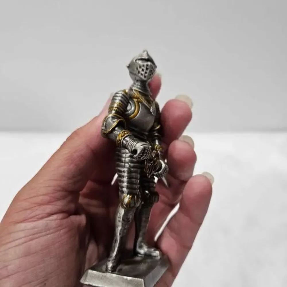 Small metal knight figurine with armor and sword